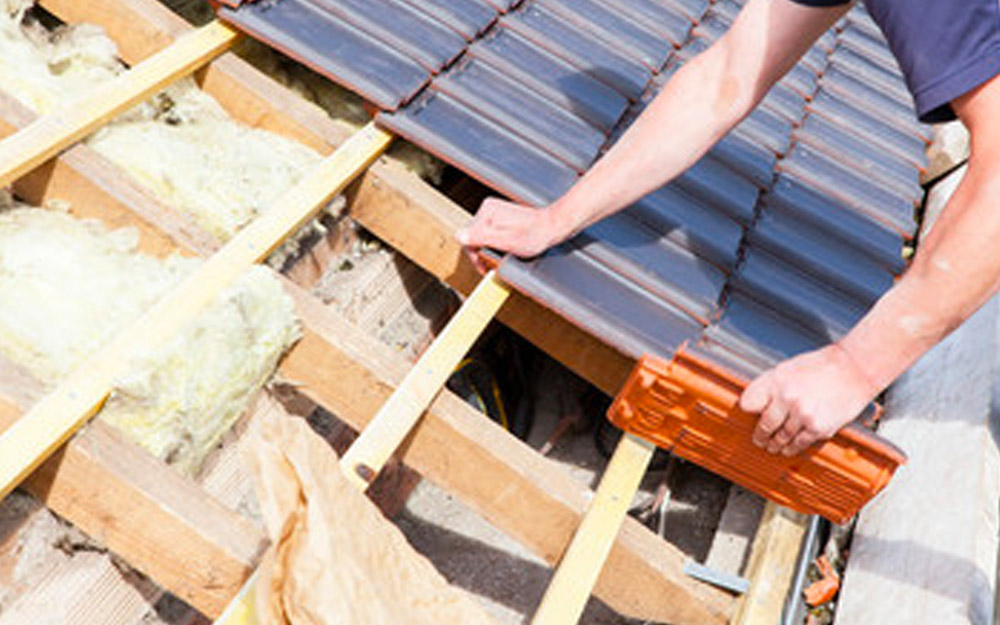 Roofer laying tiles